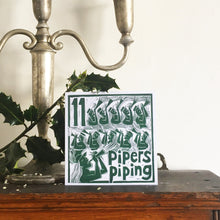 Load image into Gallery viewer, Eleven Pipers Piping Greetings Card lino cut by Kate Guy
