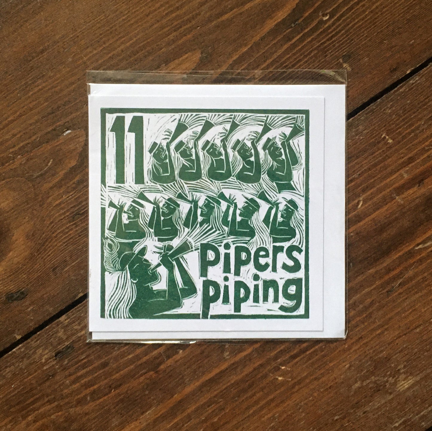 Eleven Pipers Piping Greetings Card lino cut by Kate Guy