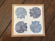 Load image into Gallery viewer, Scallop Shell Handmade tile trivet, table centrepiece. Linocut print of scallop shells in pale and dark blue on four tiles framed in English oak
