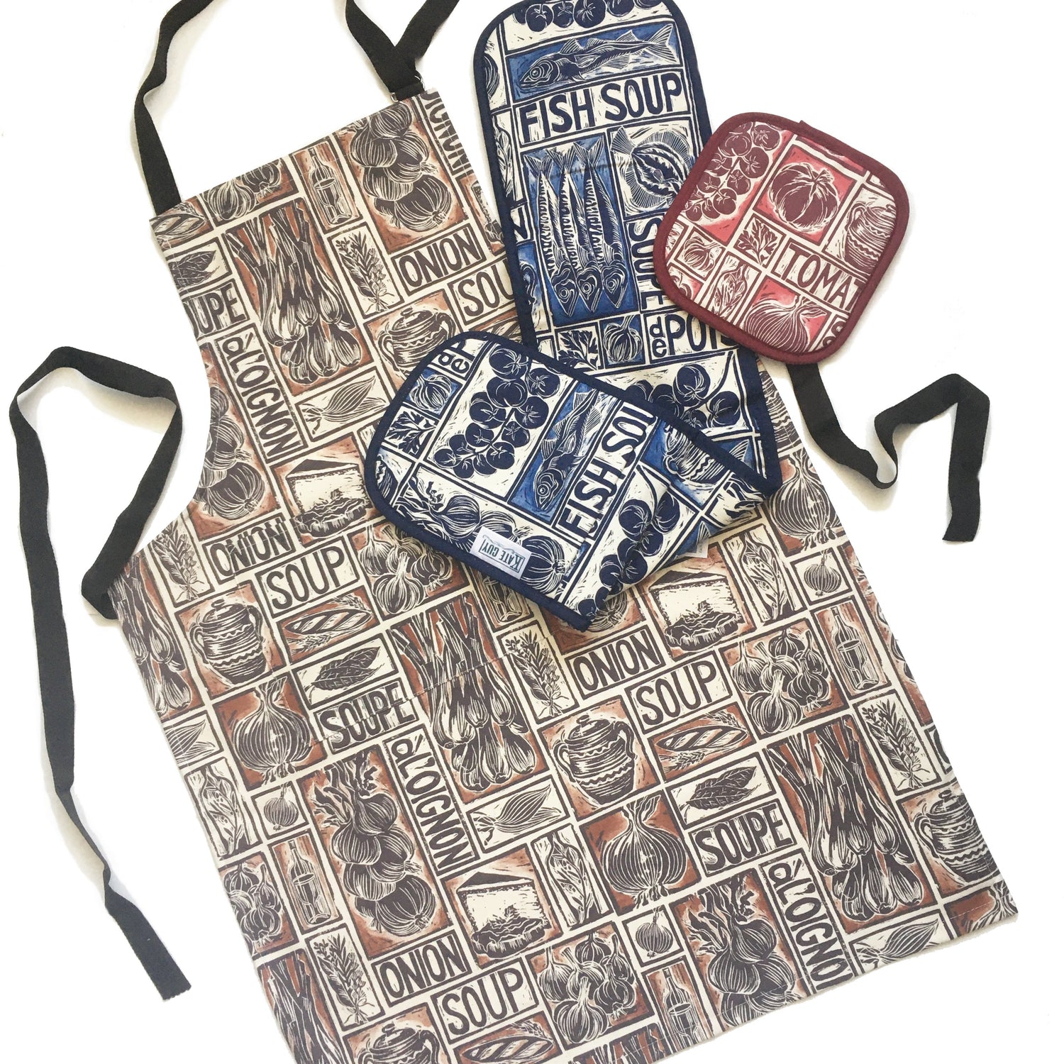 Aprons and Oven gloves with illustrated recipe lino cuts by Kate Guy. Each image is an ingredient, comes with cooking instructions