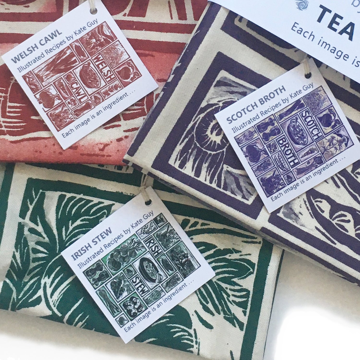 Regional Recipe tea towels lino cuts by Kate Guy. Each image is an ingredient, cooking instructions are in the tag