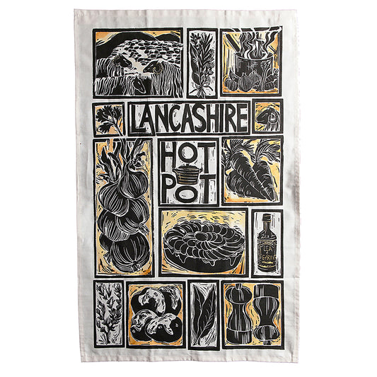 Hand-printed organic cotton tea towel with Lancashire Hot Pot recipe and linocut illustrations of sliced potatoes, lamb cutlets, and onions on a rustic wooden table, by Kate Guy