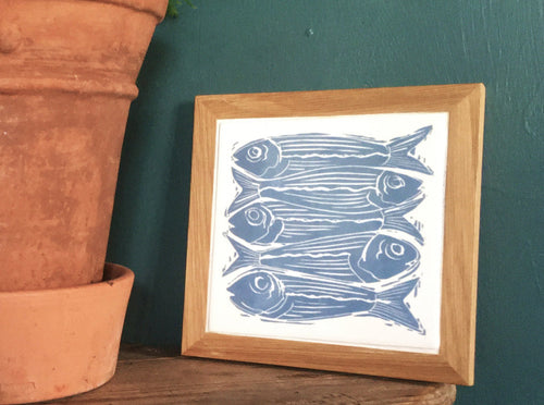 Sardines tile trivets in oak frames lino cut by Kate Guy