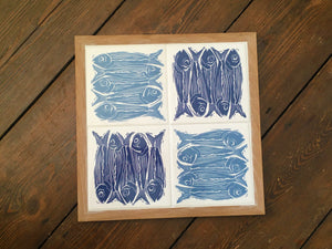 Sardines tile trivet table centrepiece in oak frames lino cut by Kate Guy in dark and pale blue