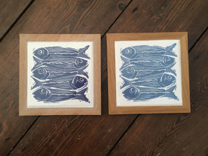 Sardines tile trivets in oak frames lino cut by Kate Guy in dark and pale blue